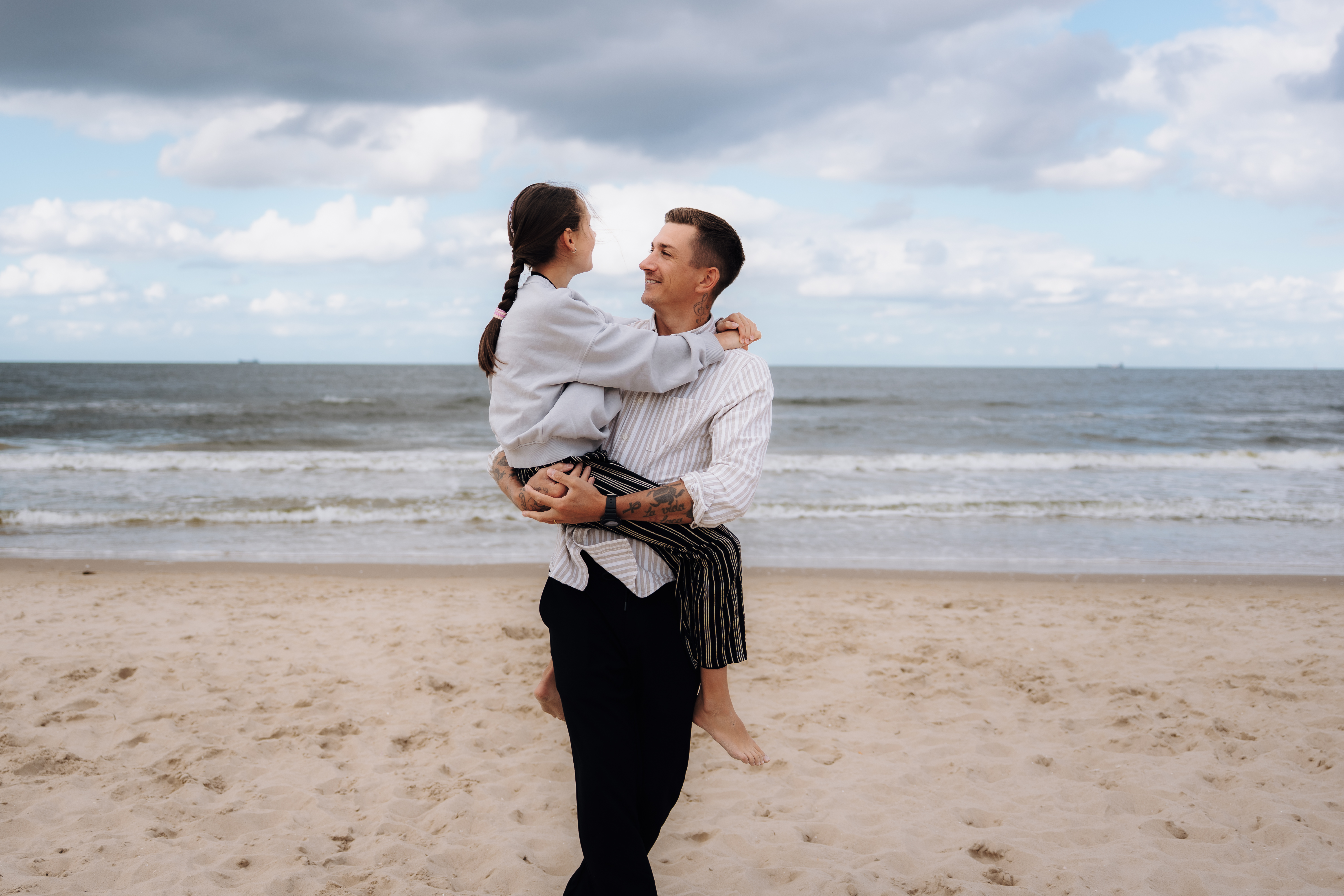 Pure Weddings – Familienmomente des Hochzeitsfotograf Freising Robert, der Hochzeitsfotograf aus Freising, hält seine Tochter liebevoll im Arm am Meer