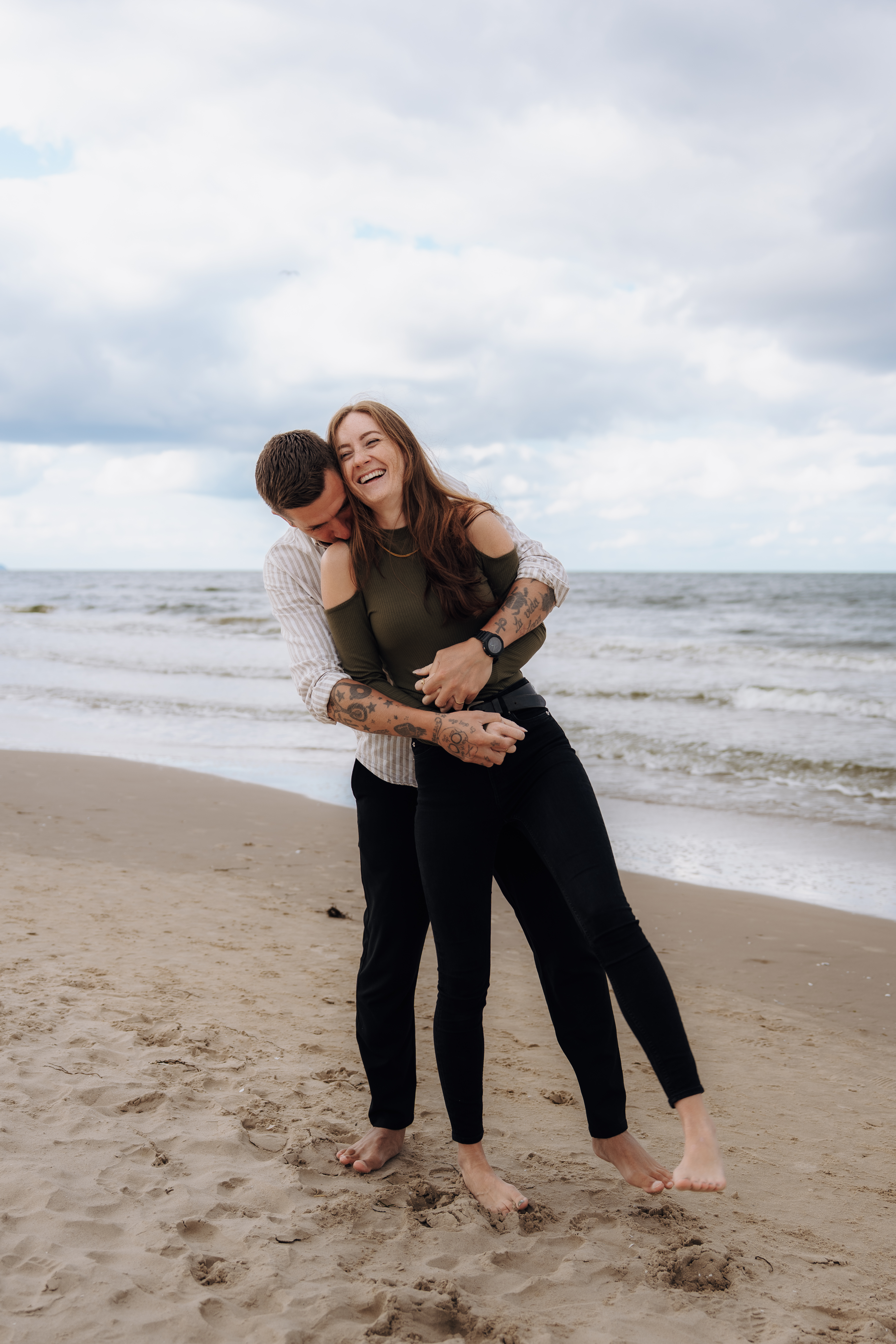 Euer Hochzeitsfotograf Freising - Pure Weddings Das glückliche Hochzeitsfotografen-Paar Stephie und Robert von Pure Weddings umarmen sich am Strand