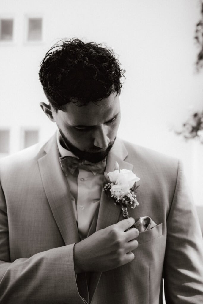 Bräutigam mit Ansteckblume vor der Hochzeit in München (Schwarz-Weiß) – Hochzeitsfotograf Freising