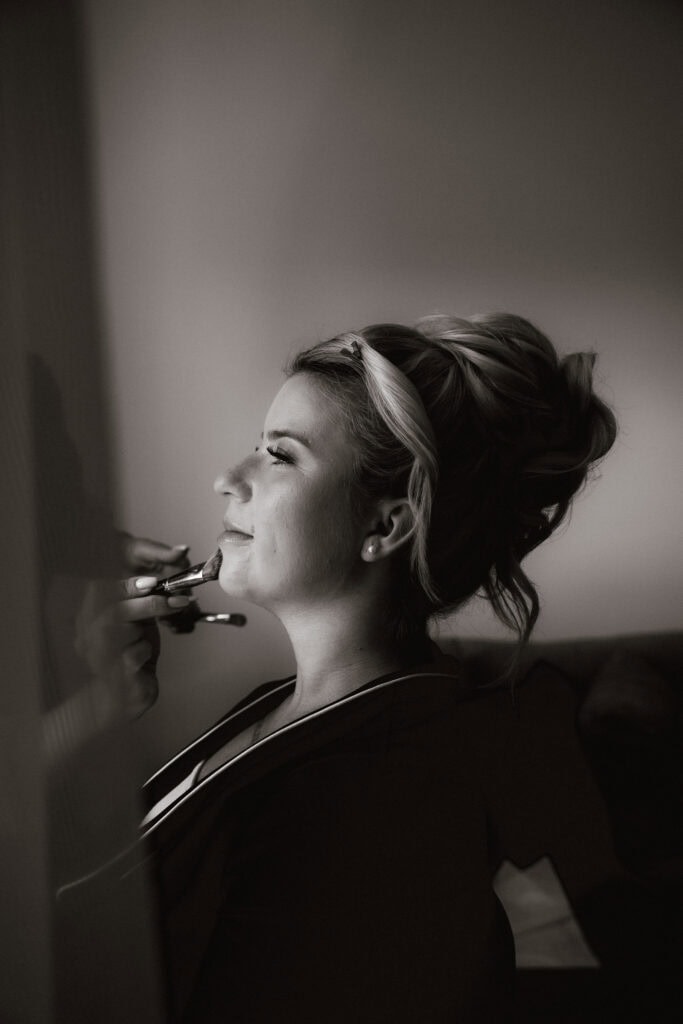 Braut beim Schminken vor der Hochzeit in München (Schwarz-Weiß) – Hochzeitsfotograf Freising