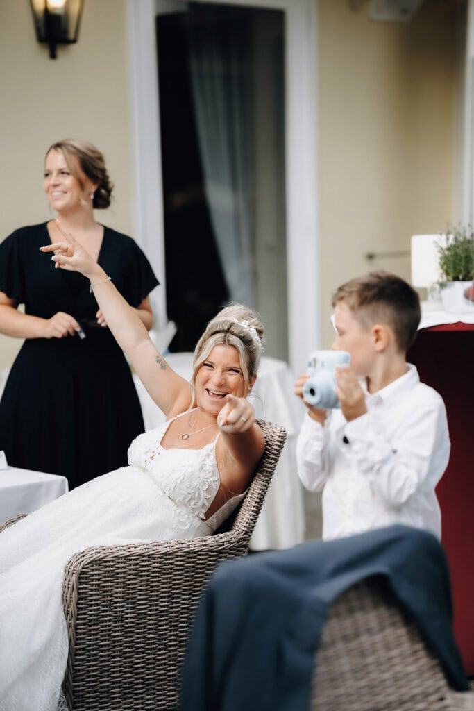 Fröhliche Braut mit einem Kind während der Hochzeitsfeier in München – Hochzeitsfotograf Freising