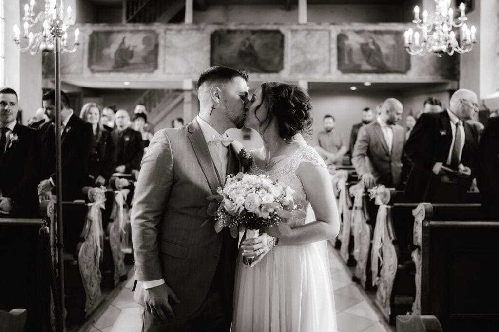 Der erste Kuss des Brautpaars vor dem Altar während einer kirchlichen Trauung in Dachau